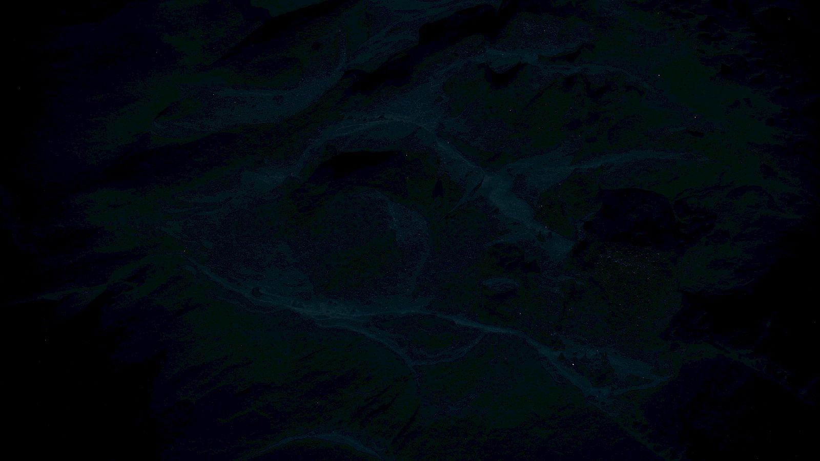 The image appears to show a dark aerial view of a landscape with rivers or roads cutting through hilly terrain.