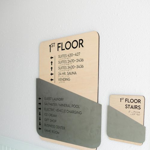 The image shows signs indicating the first floor with directions to suites, a pool, and a snack room. There's also a stairs sign.