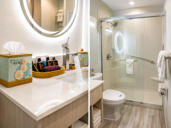 A bright bathroom with a countertop sink, soap dispensers, a tub, and a glass-enclosed walk-in shower with towels and starfish decor.